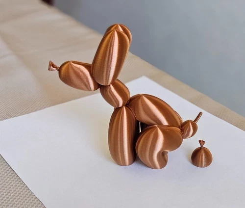Copper colored 3D printed balloon dog sculpture with a small balloon