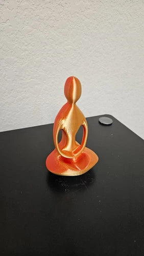 Praying man statue - shimmering red and gold colors changing colors with angle